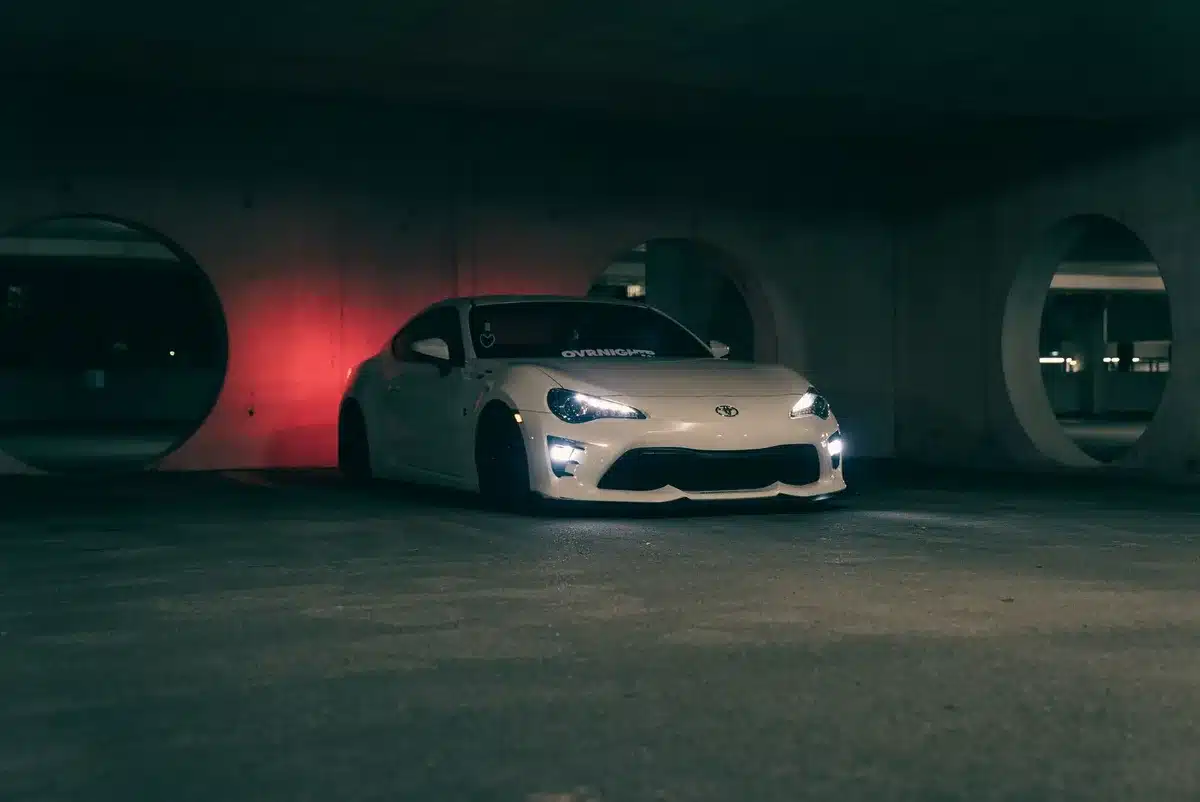 Dunkles Hochleistungsauto mit aggressivem Design und scharfen Linien in Abendlicht