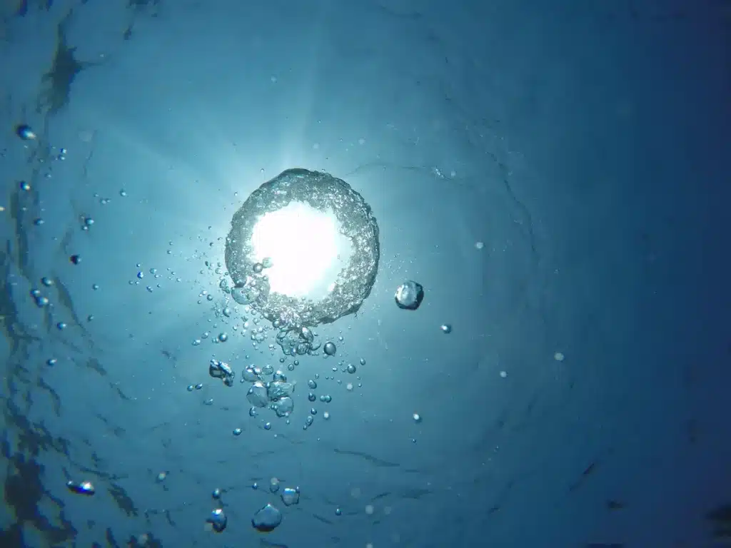 Sonnenlicht durchdringt das tiefe blaue Meerwasser und erzeugt schimmernde Muster in der Tiefe