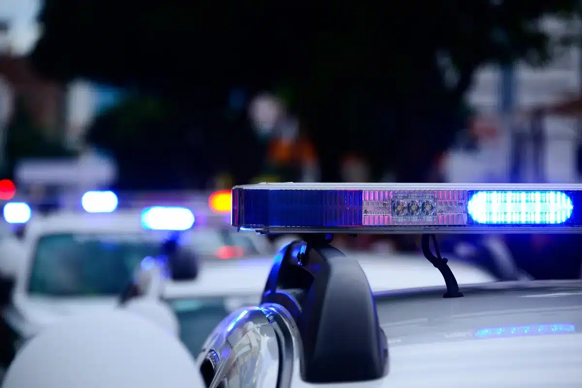Absperrband und Polizeiwagen an einem Straßenrand während einer Untersuchung