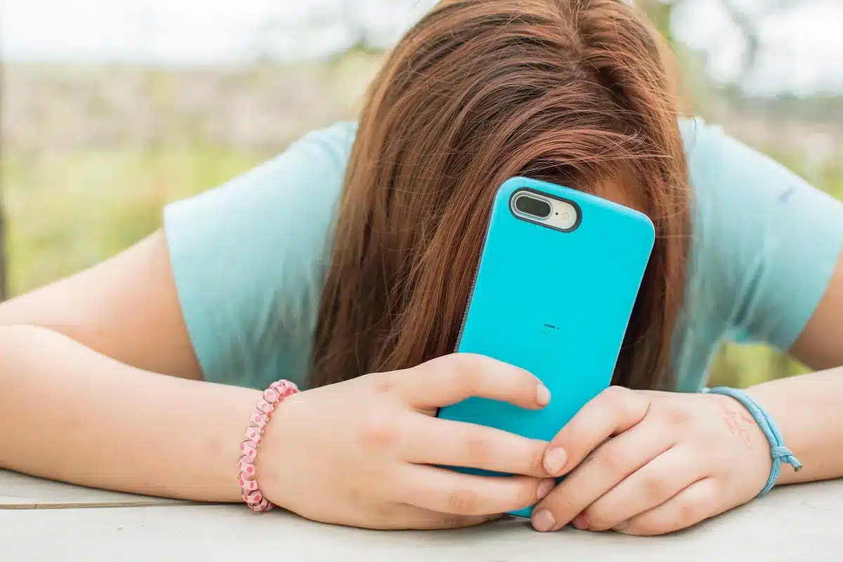 Skizzen von Modeentwürfen auf einem Schreibtisch neben einem Smartphone